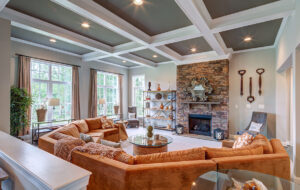 A family room with an orange couch and large windows, designed by CarrHomes home builders in Hamilton.