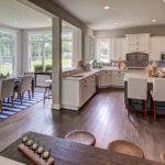 Interior home design of a kitchen and dining nook with white cabinets from CarrHomes house in Hamilton.