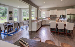 Interior home design of a kitchen and dining nook with white cabinets from CarrHomes house in Hamilton.