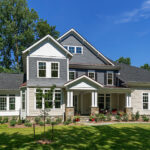 The exterior of a white, grey, and tan house from CarrHomes home builders in Hamilton.