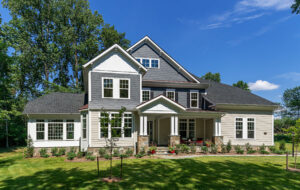 The exterior of a white, grey, and tan house from CarrHomes home builders in Hamilton.