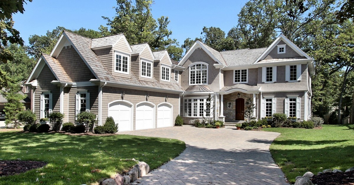 The exterior of a grey designer home with a three-car garage built by CarrHomes in Hamilton.