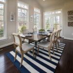 The dining area with six dining chairs, a table, and rug in a home for sale from CarrHomes in Hamilton.